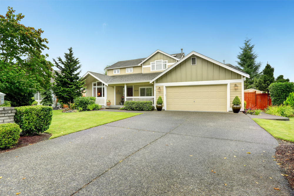 House exterior. Spacious walkout deck with railings. Garage with driveway